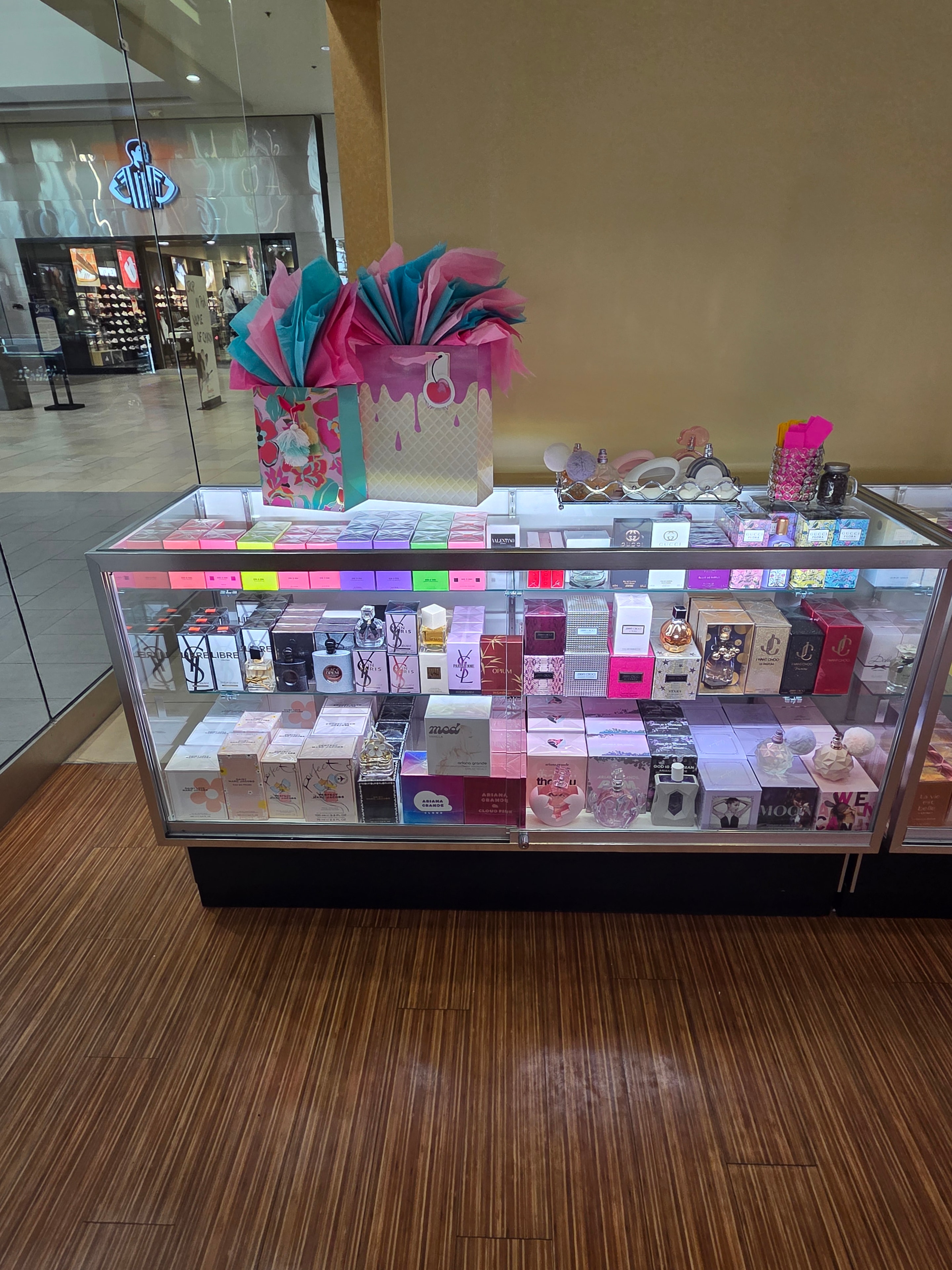 Backlit display case showcasing feminine fragrance collections