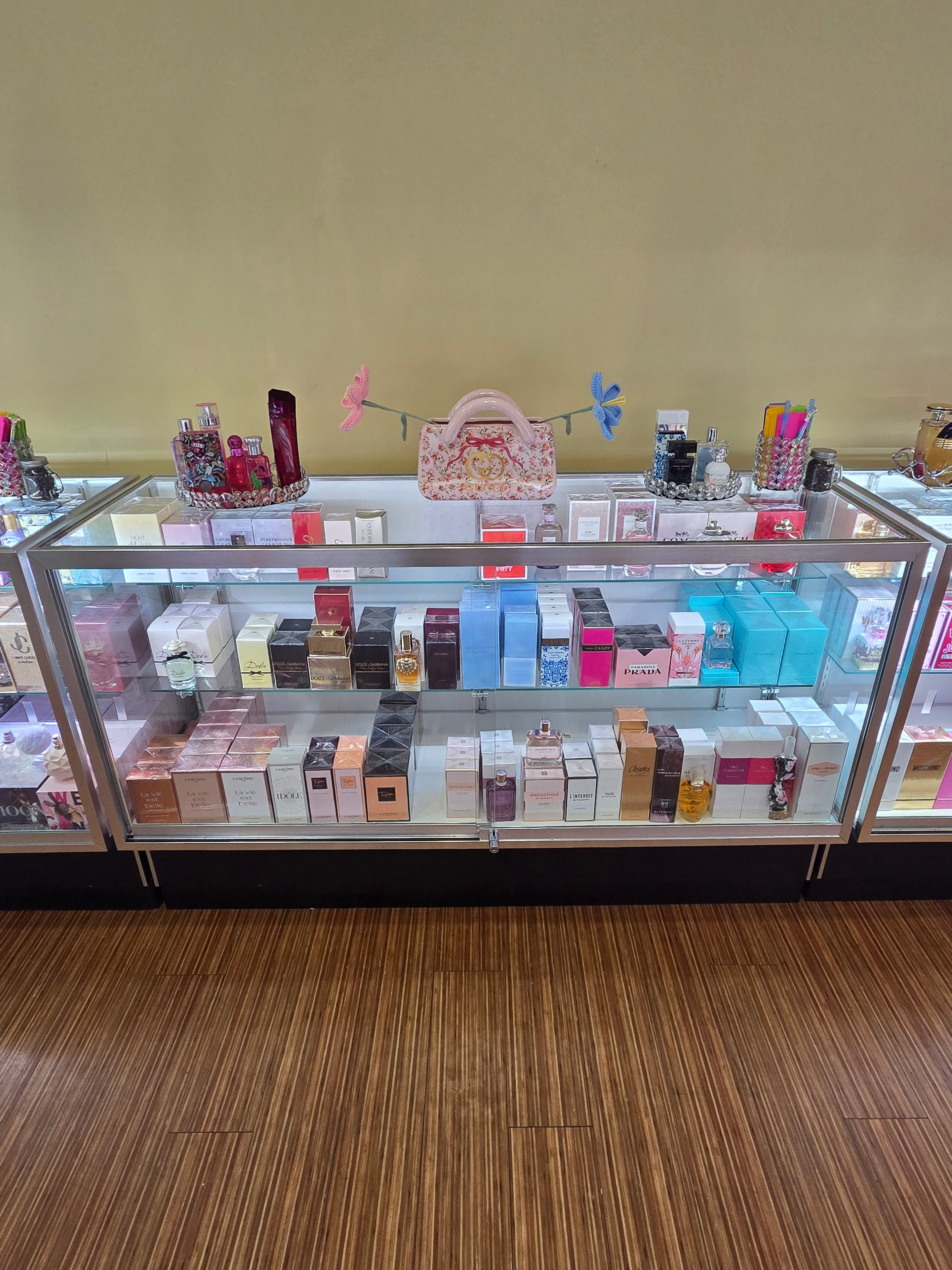 Glass display case with Prada, Chanel and luxury fragrance boxes