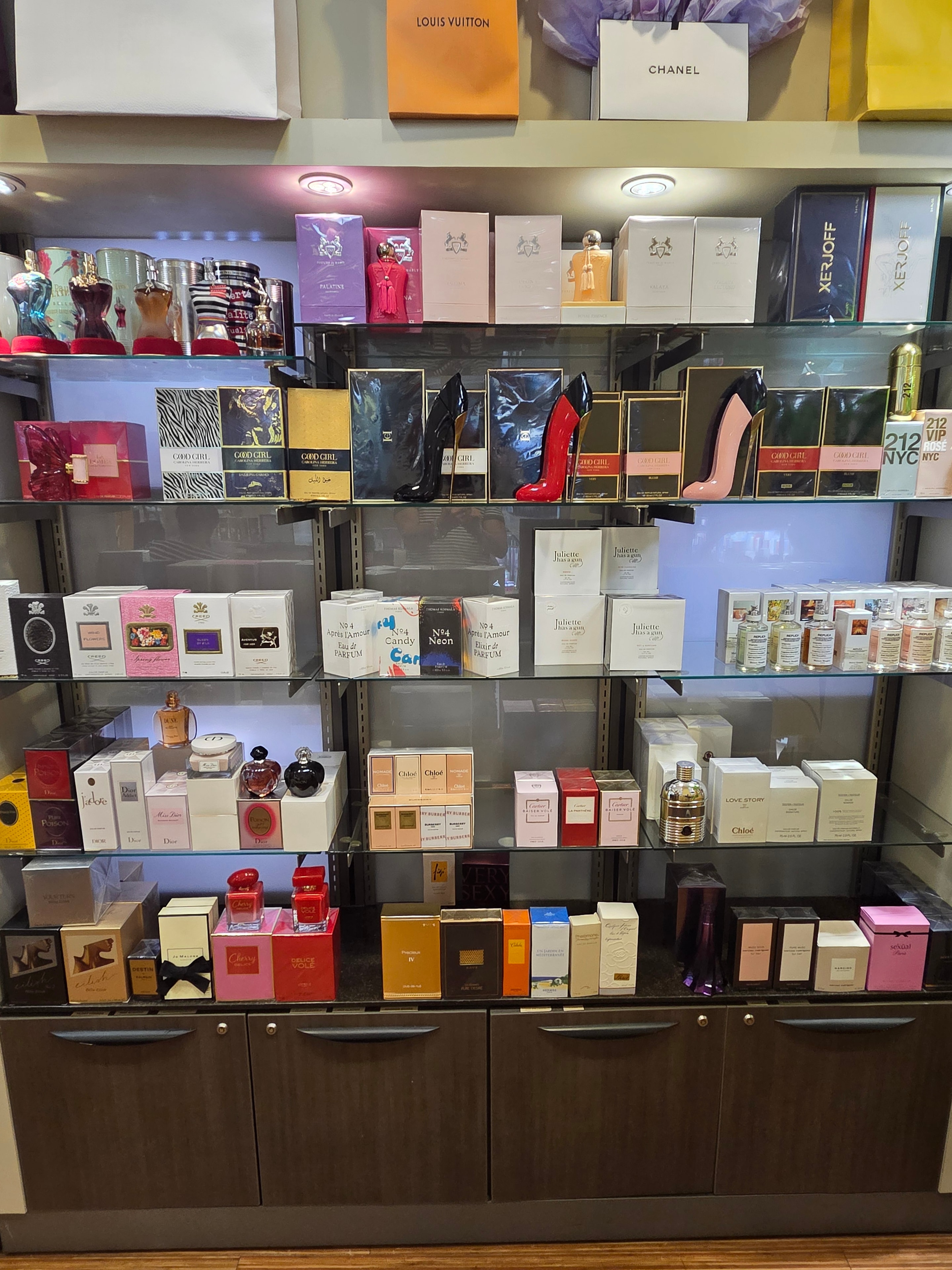 Glass shelves displaying premium and niche fragrance brands